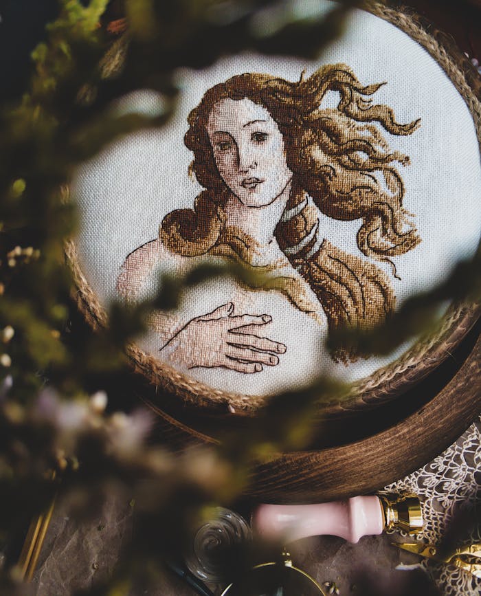 Detailed embroidery art depicting a vintage style portrait, creatively fashioned in a warm setting.