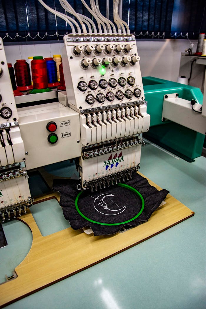High-quality embroidery machine stitching fabric in an industrial setting in Apucarana, Brazil.